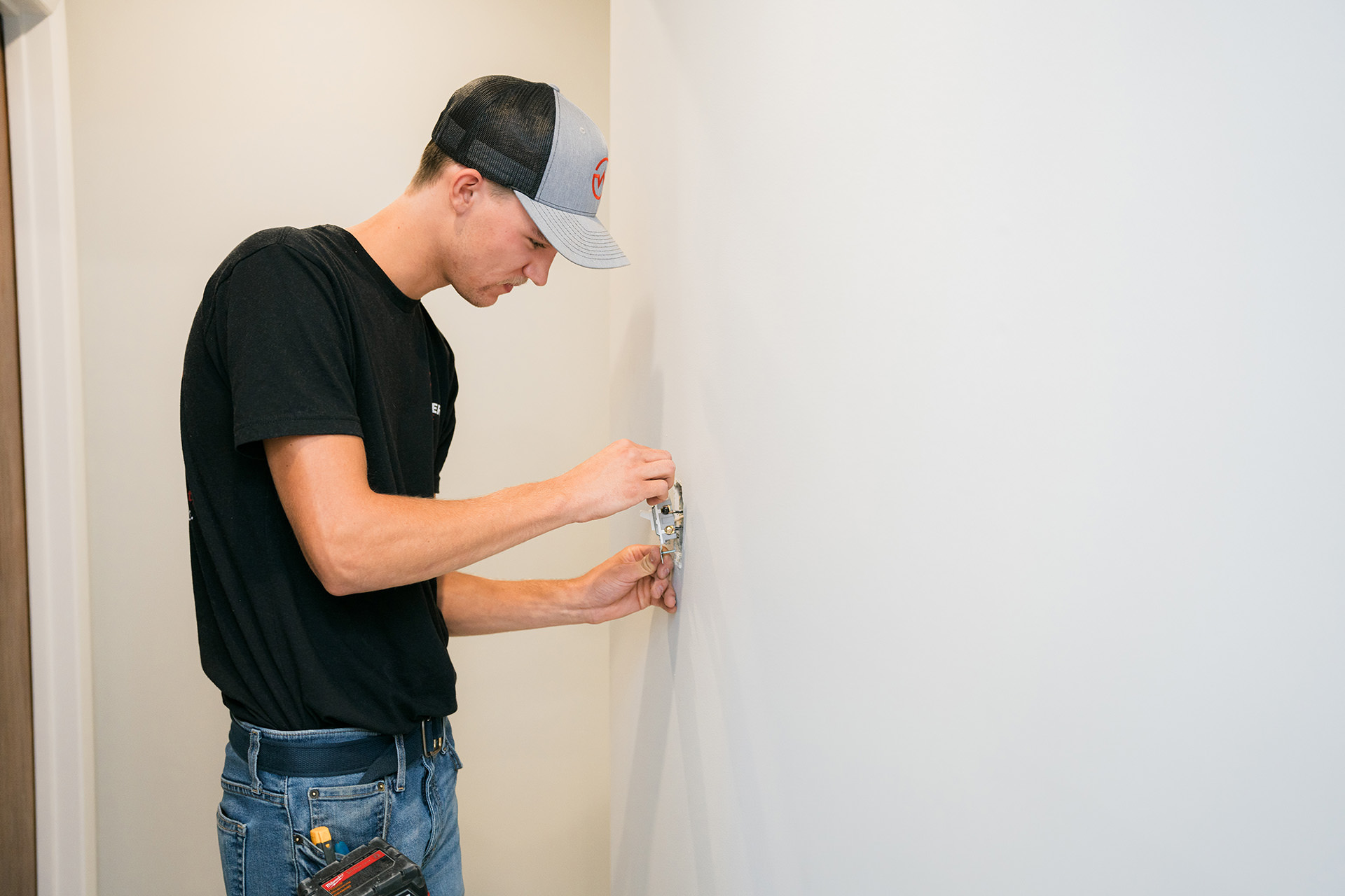 Professional electrician changing a light switch in a residential home.