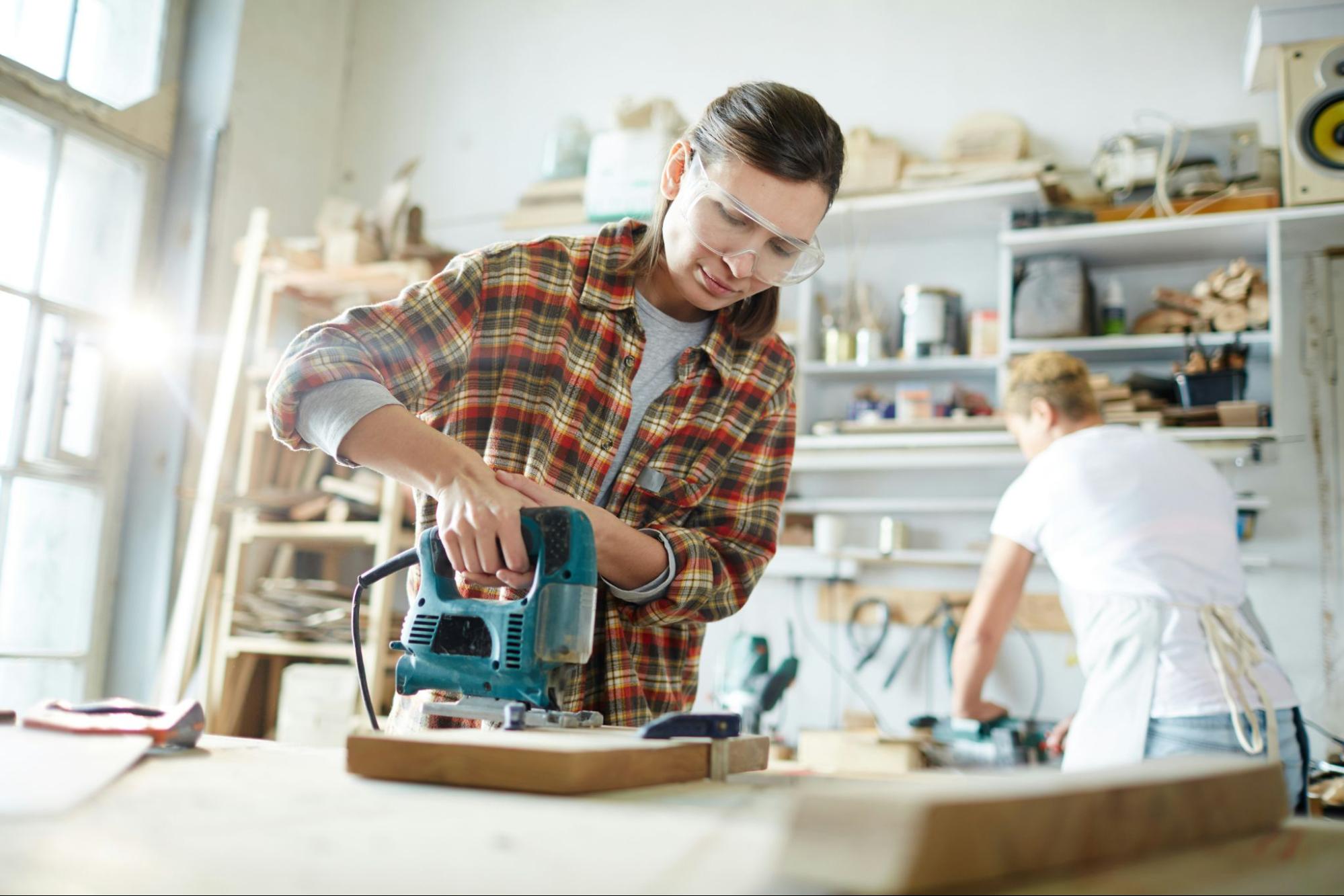 Homeowner using a power tool in a workshop while working on a DIY home improvement project, highlighting the electrical demand of power tools during spring projects.
