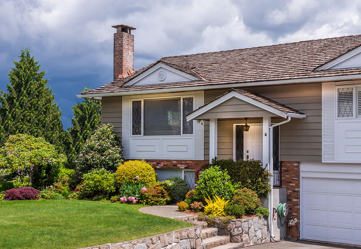 A residential home with storm clouds behind it.